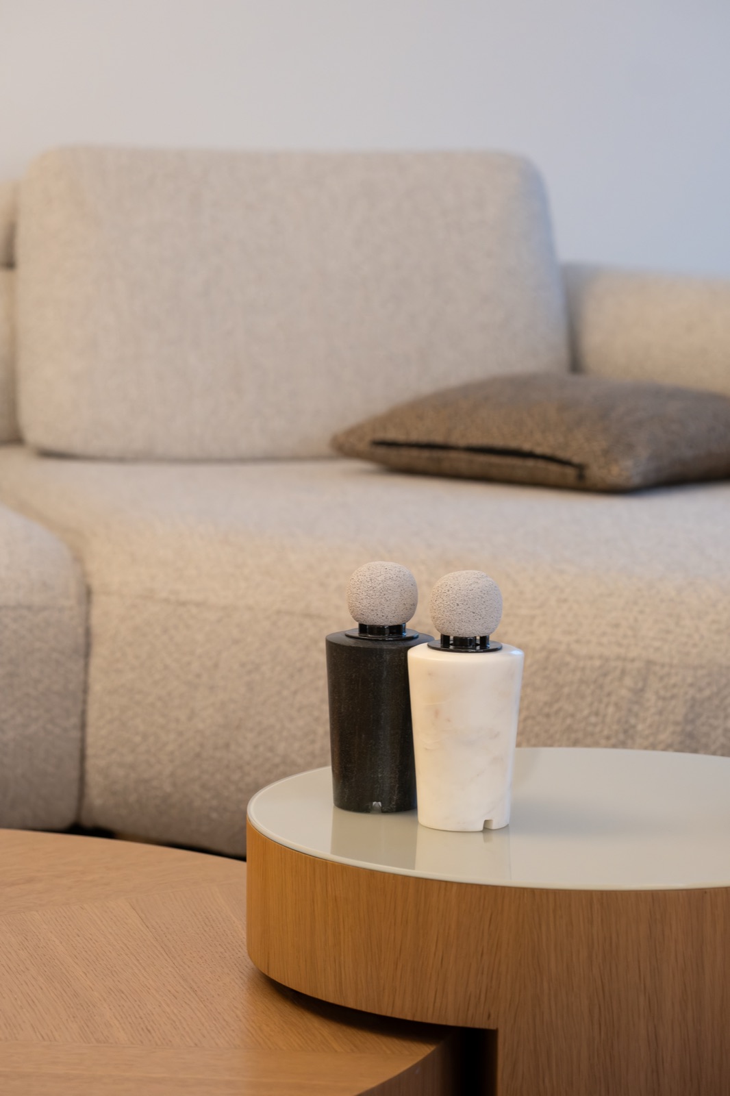 A black and a white marble diffuser side by side on a round side table
